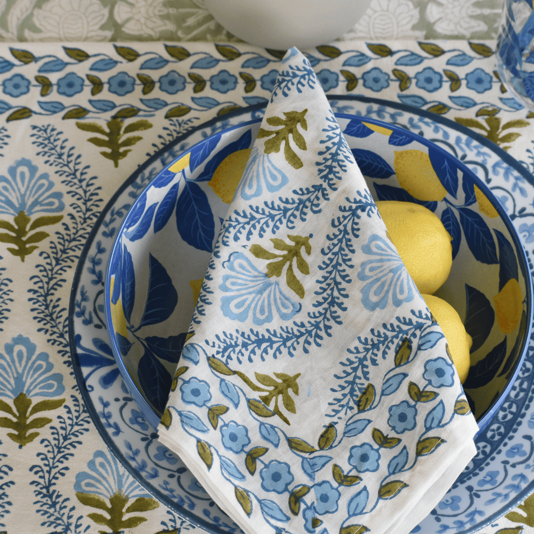 Decorative floral-patterned napkin on a blue and white plate with lemons