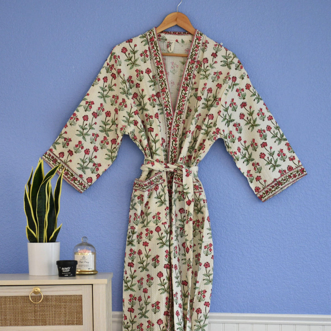 Waffle cotton robe with pink vine floral block print hanging on wooden hanger.