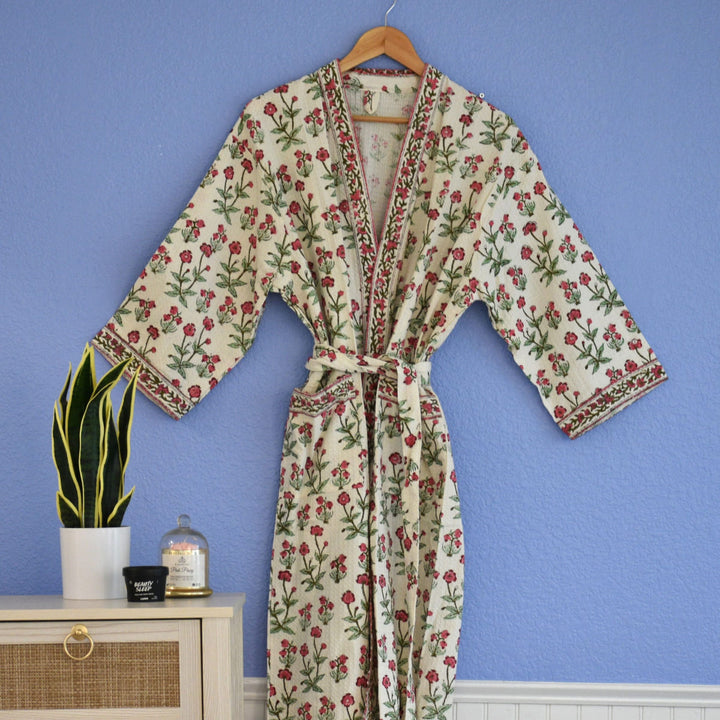 Waffle cotton robe with pink vine floral block print hanging on wooden hanger.