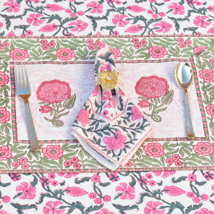 Floral table setting with pink and green flowers on a white background