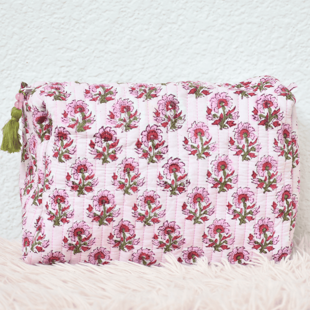 Floral patterned pouch with tassels on a textured white background