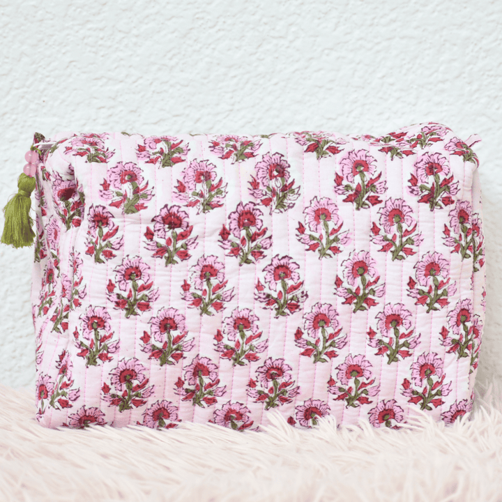 Floral patterned pouch with tassels on a textured white background
