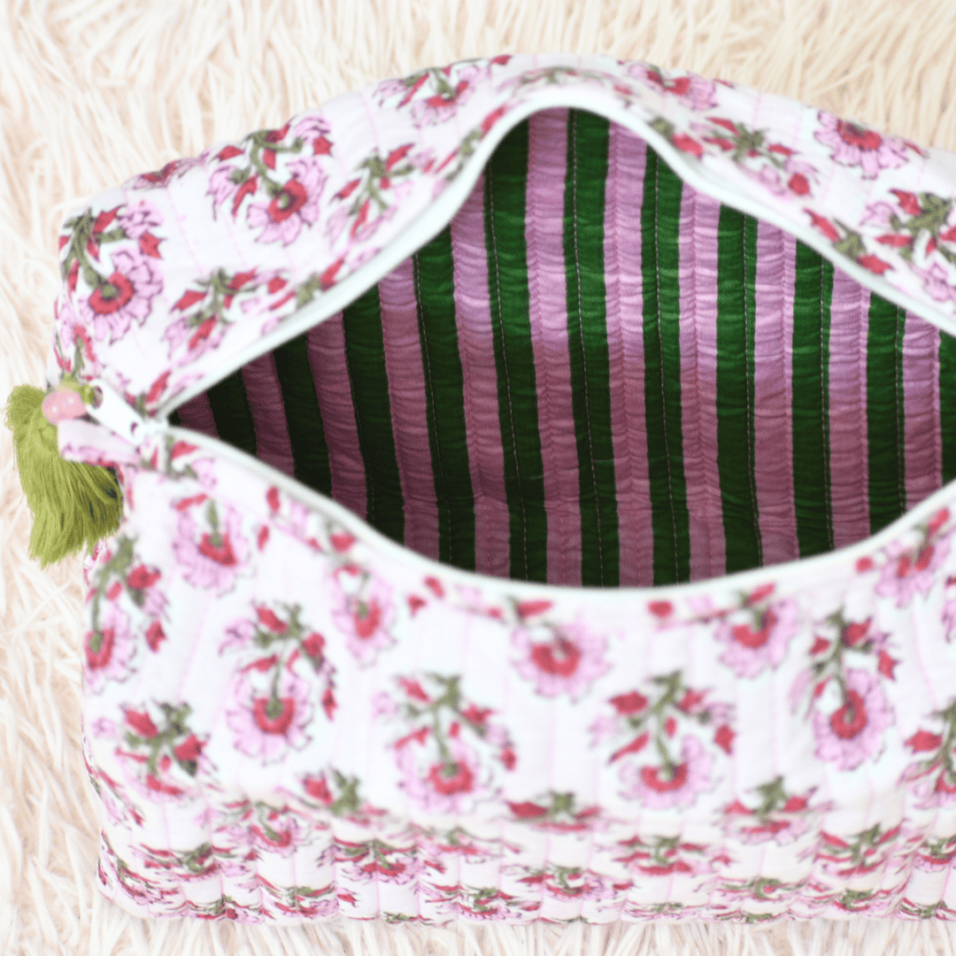 Floral-patterned pouch with striped interior on a light wooden surface