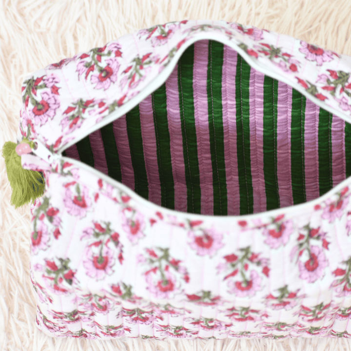 Floral-patterned pouch with striped interior on a light wooden surface