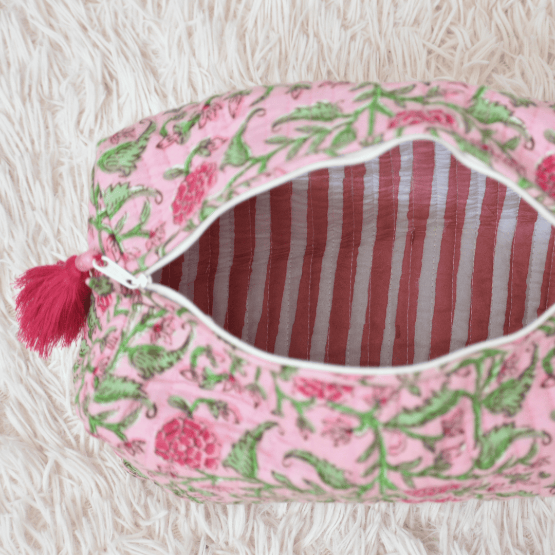 Pink and green patterned pouch with red striped interior on a white background