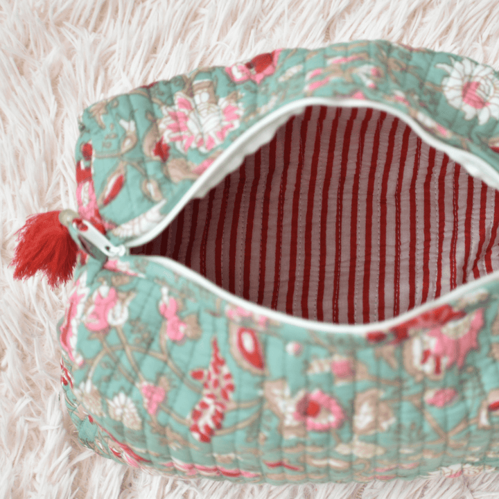 Floral-patterned pouch with red interior on a soft surface
