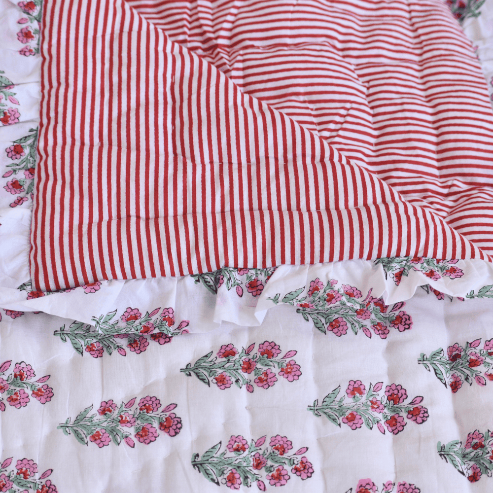 Red and white striped throw on top of a floral-patterned fabric