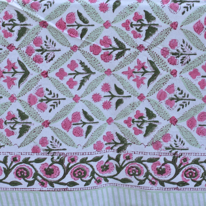 Patterned fabric with pink flowers and green leaves on a white background