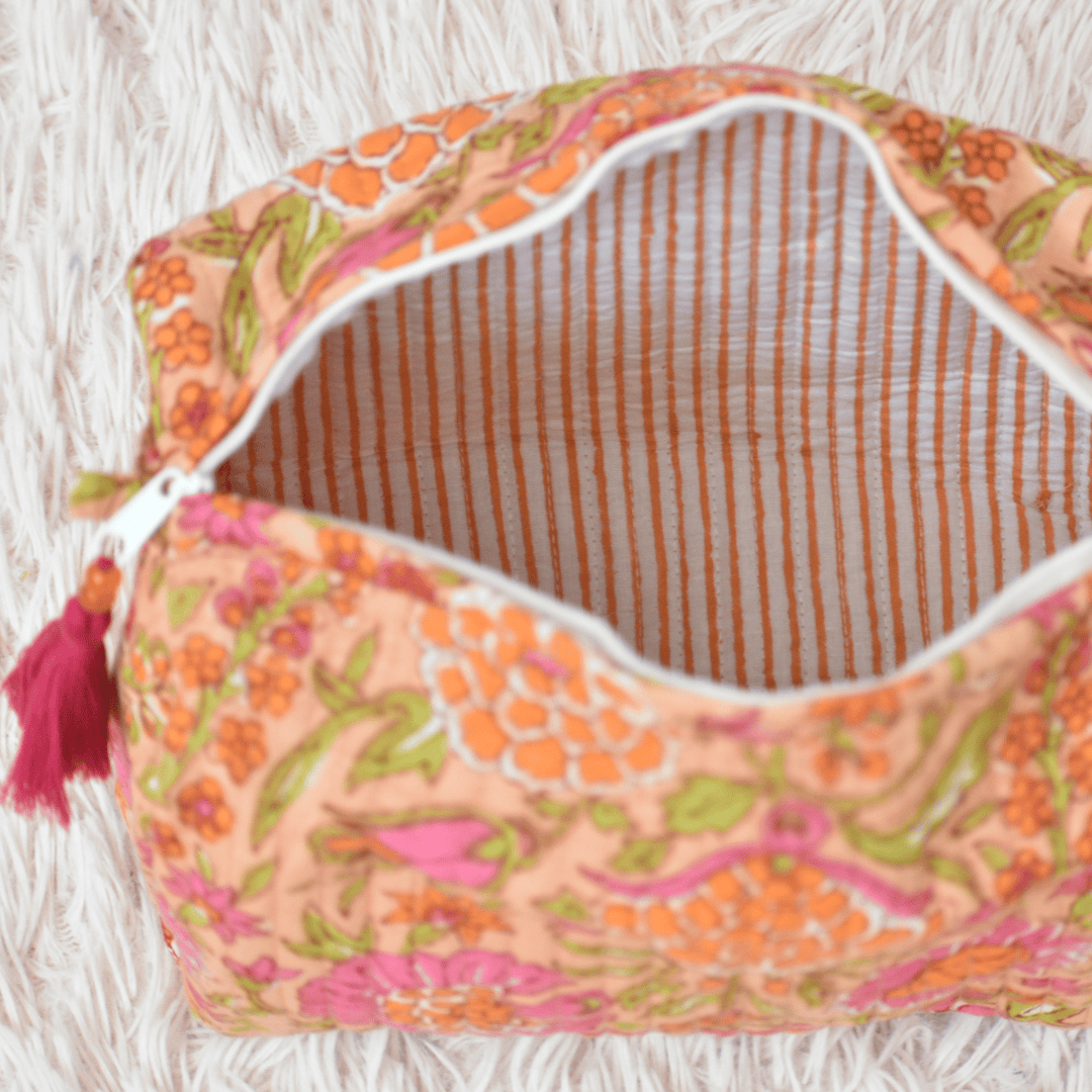 Floral patterned pouch with a tassel on a textured surface