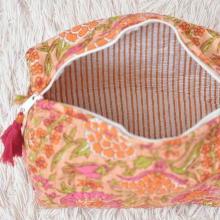Floral patterned pouch with a tassel on a textured surface