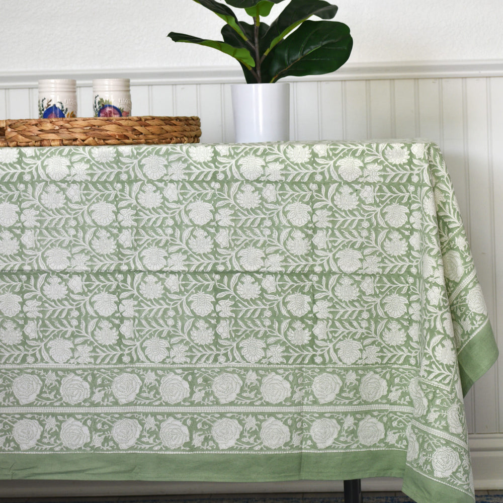 Palm Meadows - Handblock Print Cotton Tablecloth in green floral print, styled on a dining table with plant decor.